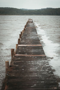 Surface level of pier over lake against sky