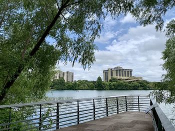 Scenic view of river by buildings against sky