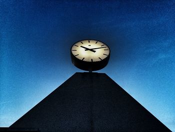 Low angle view of clock against clear blue sky