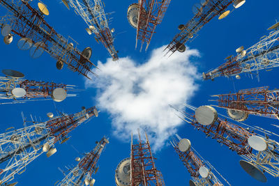 Low angle view of communications tower against blue sky