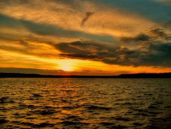 Scenic view of sea against dramatic sky during sunset