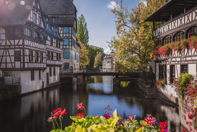 Canal amidst buildings in city against sky