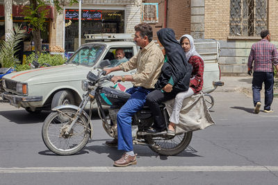 People riding motorcycle on street in city