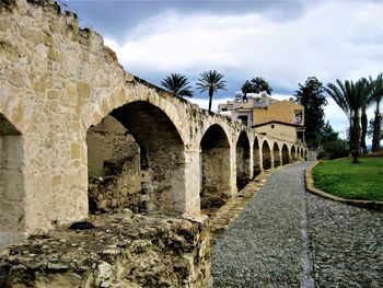 Arch bridge amidst buildings against sky