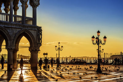 People walking in city during sunset