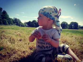 Boy wearing sunglasses on field against sky