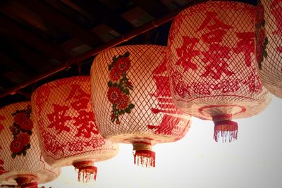 Low angle view of illuminated lanterns hanging on ceiling in building