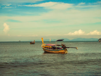 Fishing boat in sea against sky