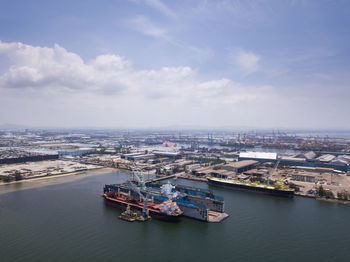 High angle view of city by river against sky