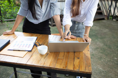 Midsection of people working at table