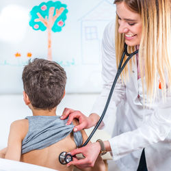 Female doctor examining boy at clinic