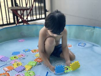 Boy playing with toy in swimming pool