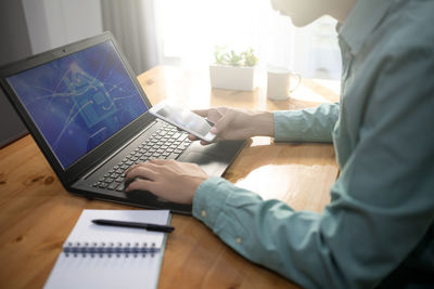 High angle view of woman using laptop on table