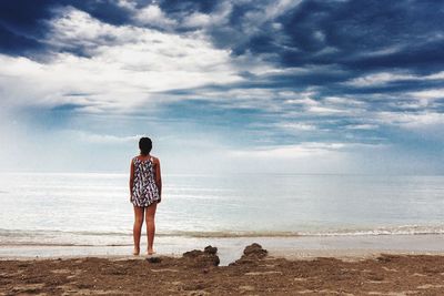 Rear view of man looking at sea against sky