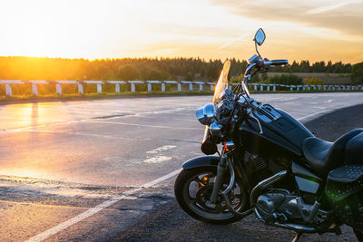 View of a cruise motorcycle, chopper class, parked by an asphalt road, highway