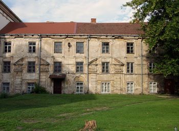 Houses by lawn and building against sky