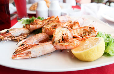 Close-up of shrimps with lemon slice in plate