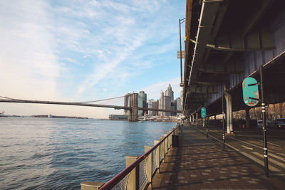 Bridge over river in city against sky