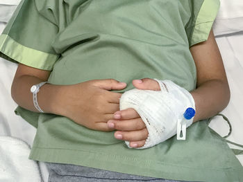 Midsection of patient lying on bed at hospital