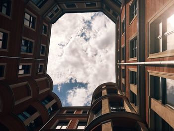 Low angle view of buildings against cloudy sky