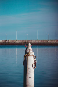 Pier by sea against blue sky