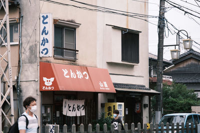 Information sign on street amidst buildings in city