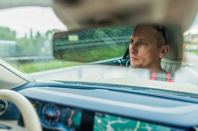 Portrait of man looking through car window