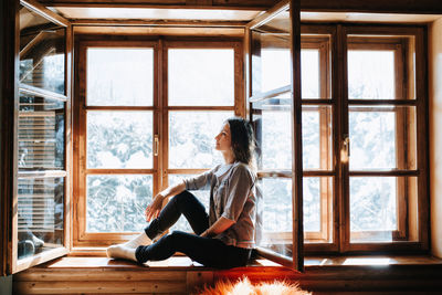 Full length of woman sitting at window