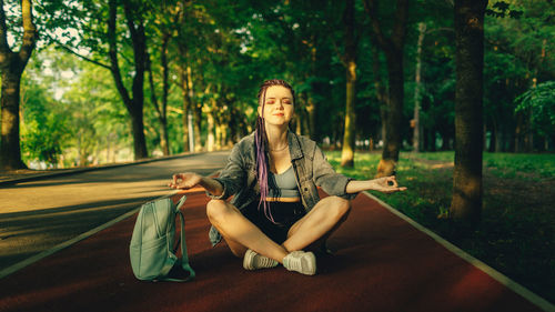 Portrait of young woman sitting in park