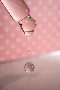 A dripping pipette with a drop of cosmetics gel.