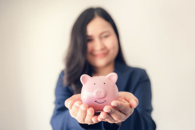 Portrait of a smiling young woman holding camera