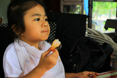 Cute girl eating food at home