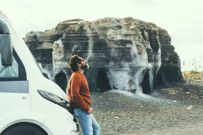 Rear view of man standing against waterfall