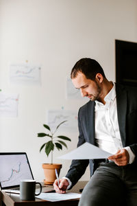 Young man using mobile phone while sitting on table