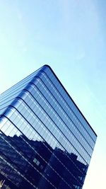 Low angle view of office building against blue sky