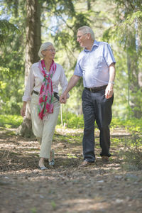 Full length of couple standing against trees