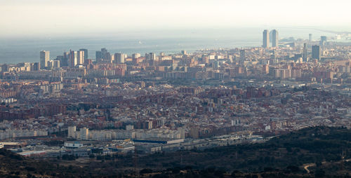 Aerial view of buildings in city against sky