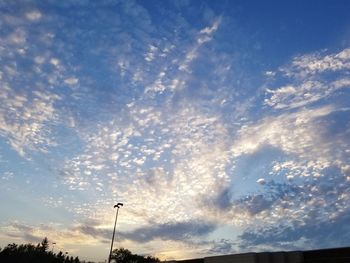 Low angle view of street light against dramatic sky