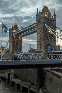 Bridge over river against cloudy sky