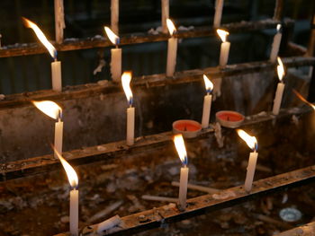 Close-up of illuminated candles against building