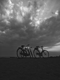 Bicycle parked on field against sky