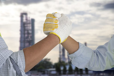 Close-up of hand holding umbrella against sky