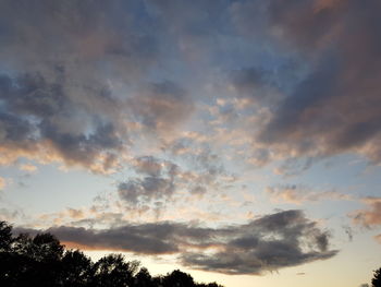 Low angle view of silhouette trees against dramatic sky