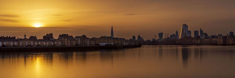 View of buildings at waterfront during sunset