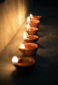 Close-up of illuminated tea light candles on table