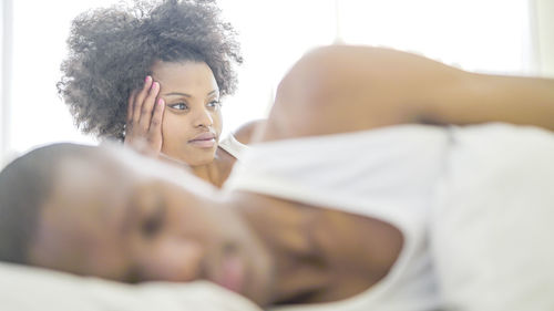 Close-up of young woman lying on bed