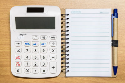High angle view of calculator and paper on table