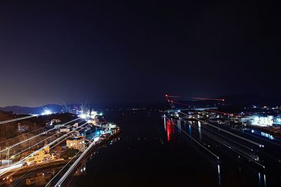 High angle view of illuminated cityscape against sky at night