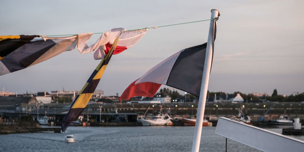 Boats in river against sky in city