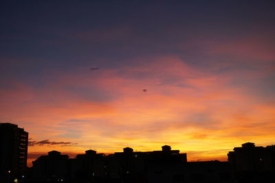 Silhouette buildings against sky during sunset